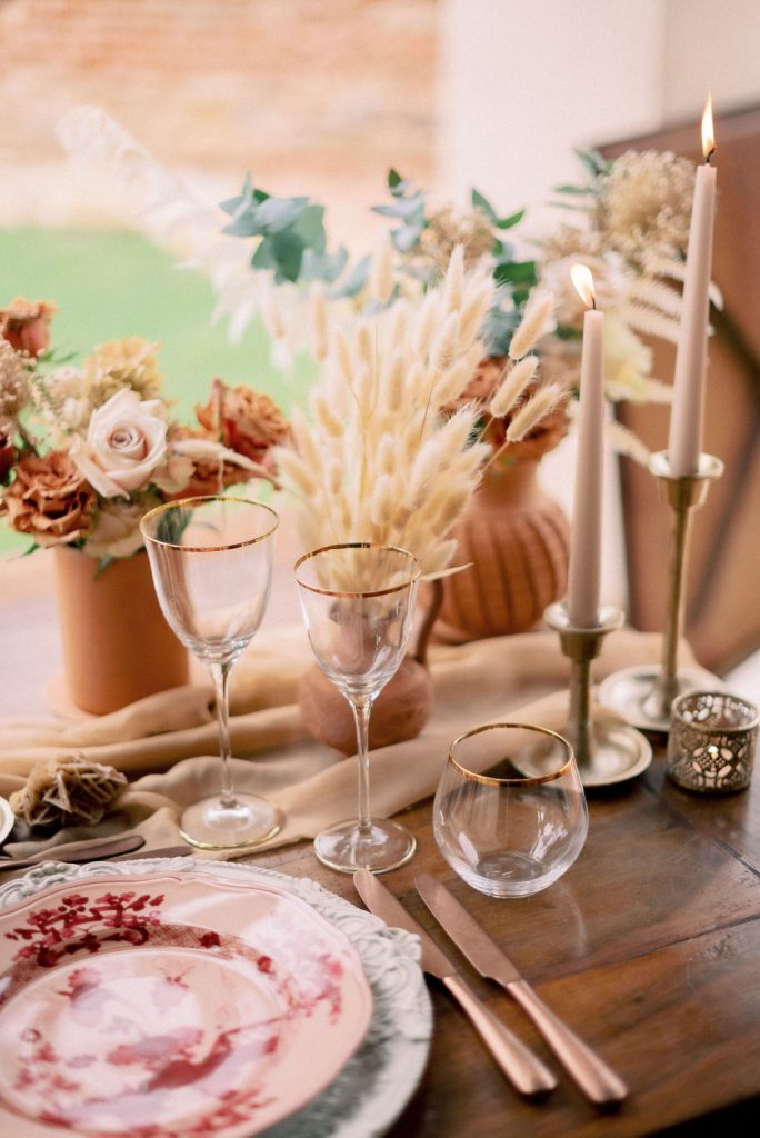 Mis en place e allestimento tavola matrimonio in stile raffinato e chic dai colori terracotta, sabbia e bronzo, su un tavolo in legno