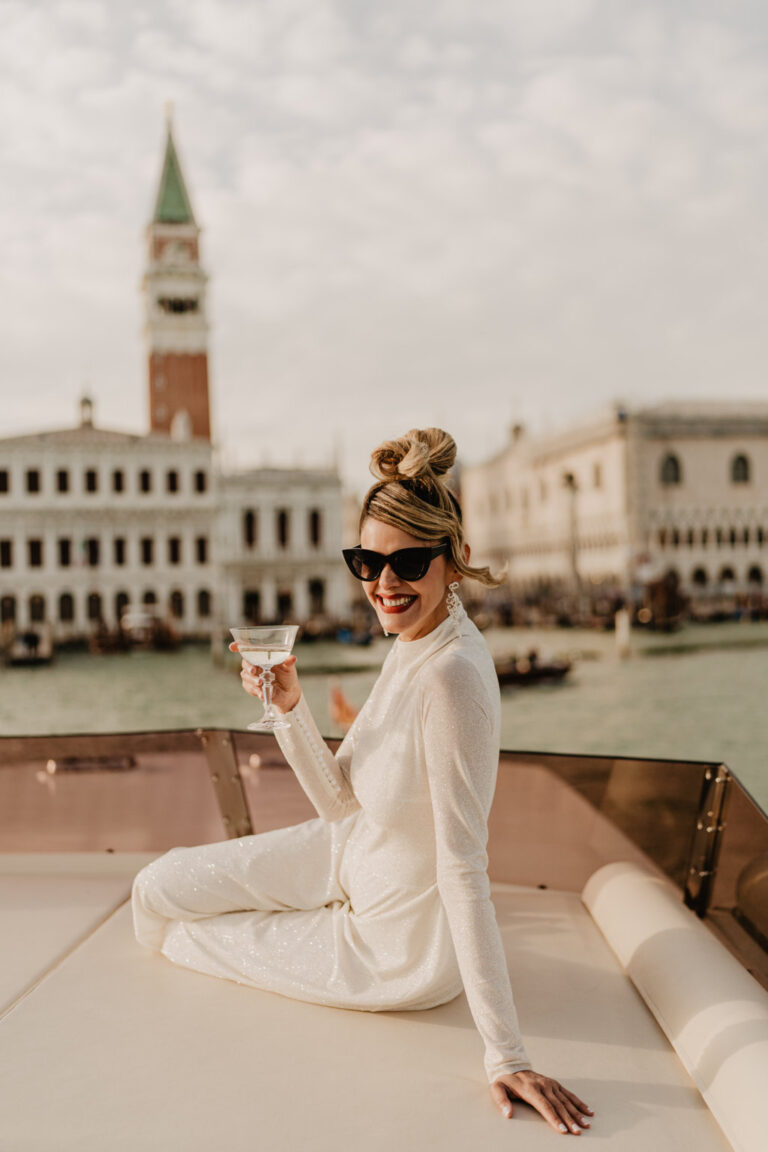 Sposa glamour a Venezia con calice di vino e sullo yatch